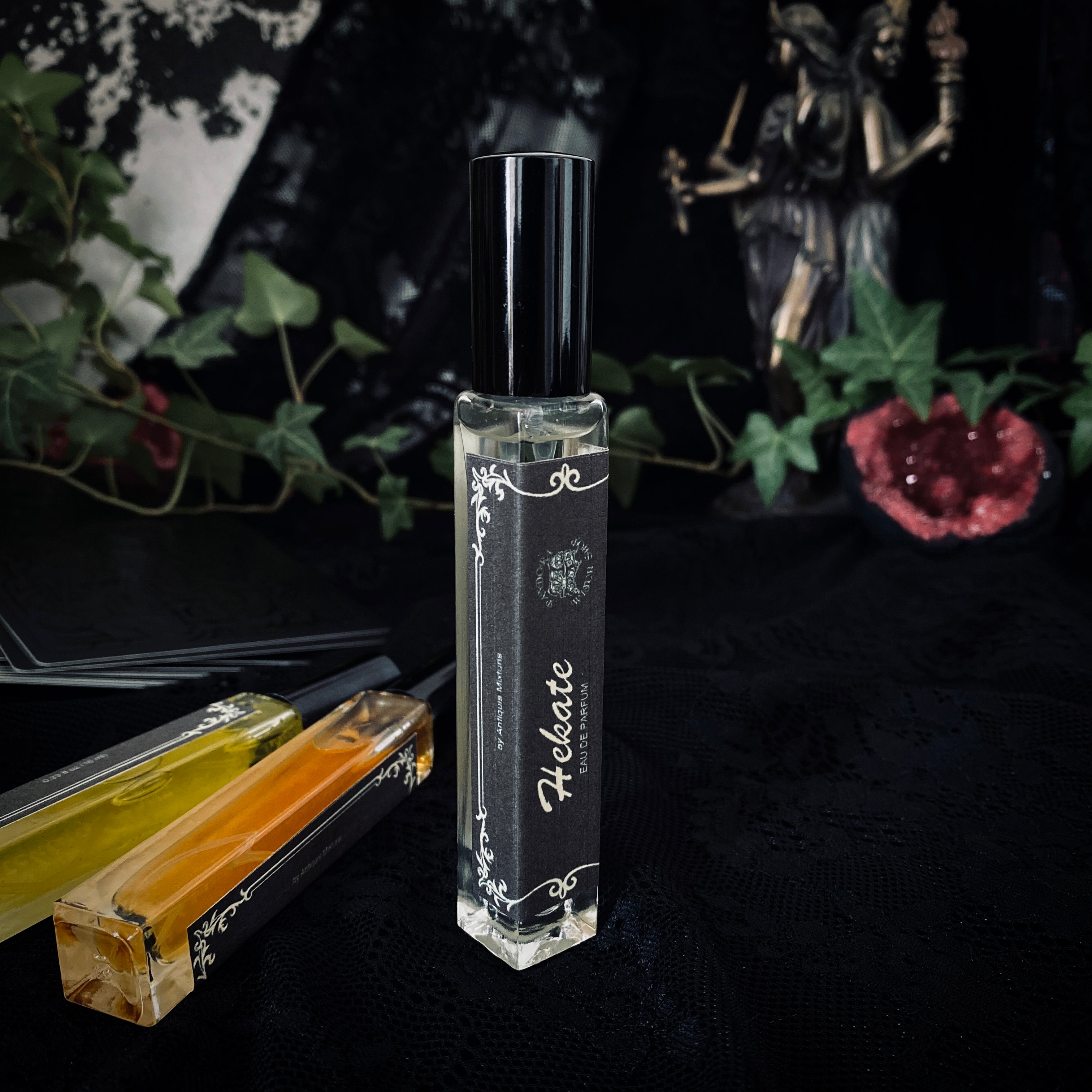 Perfume bottle labeled 'Hecate' on a dark background with decorative elements.