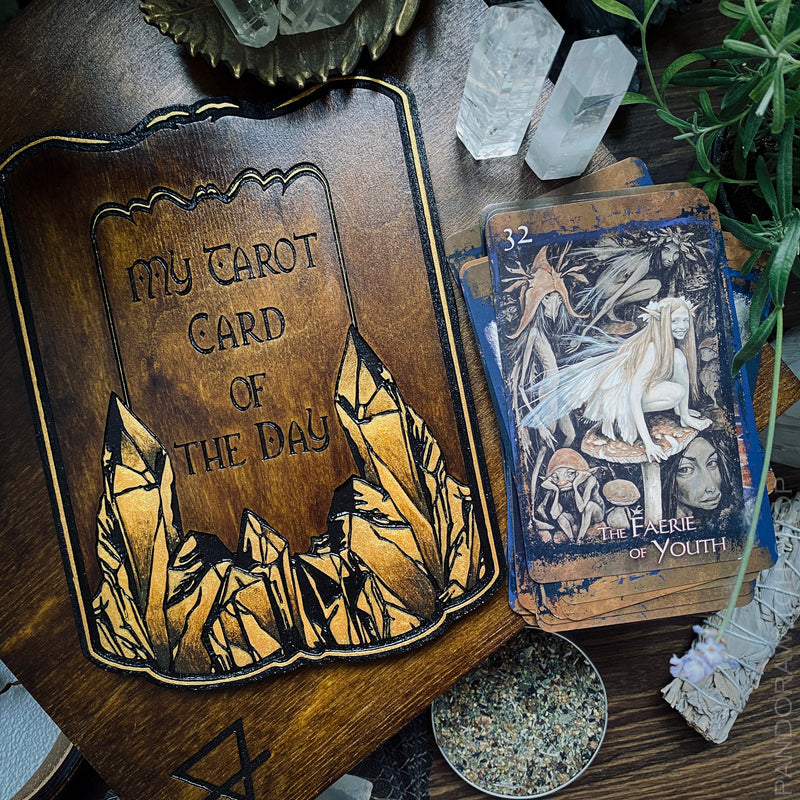 Start every morning off right with the Tarot Board Card of the Day - Golden Crystals! This exclusive wooden board is engraved with a classic Tarot card spread and is perfect for your Tarot or Oracle cards. Enjoy a cozy morning ritual as you tap into the energy of each new day. Handcrafted with care, this is the perfect item for any Tarot lover.